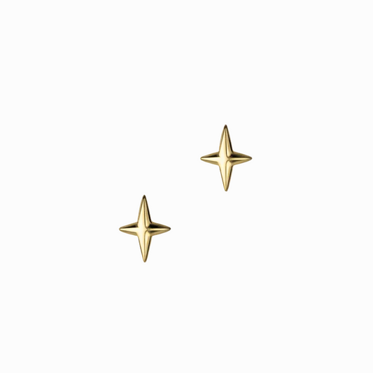 Gold star-shaped earrings on a marble surface